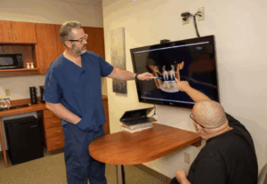 Dr. Leslee C. Timm working with a patient on the process of dental implants.